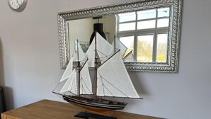 Een houten dressoir met een modelboot erbovenop.