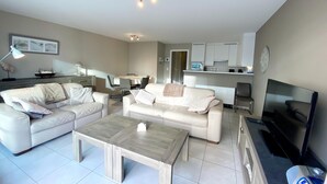 Ein modernes Wohnzimmer mit Sofa, Couchtisch und Fernseher.