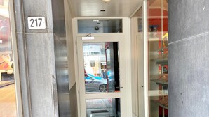 Ein Hotel Eingang mit Glastür, Nummer 217 Schild und einem 'Lots of Lollies' Schild an der Wand.