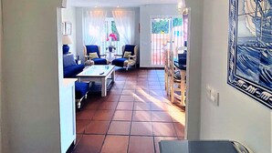 A living room with a sofa, chairs, a coffee table, and a dining area with chairs and a table. - Belvilla by OYO Holiday Home in Rota (Rota)