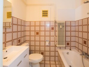 A bathroom with a toilet, sink, and bathtub. - Studio Near the Casino Square (Middelkerke)