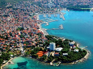 An aerial view of a coastal city with dense urban development, a marina, and a small island with buildings. - Apartment in Uberlingen (Vodice)