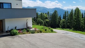 A modern two-story building with a concrete driveway leading to a covered porch. - Flat in Wagrain Near Ski Slopes (Wagrain)
