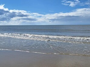 A beach with waves, a clear sky, and a distant horizon. - 4 Star Holiday Home in Blavand (Blavand)