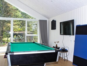 A pool table in a room with a large window, a television, and a blue cabinet. - 4 Star Holiday Home in Blavand (Blavand)