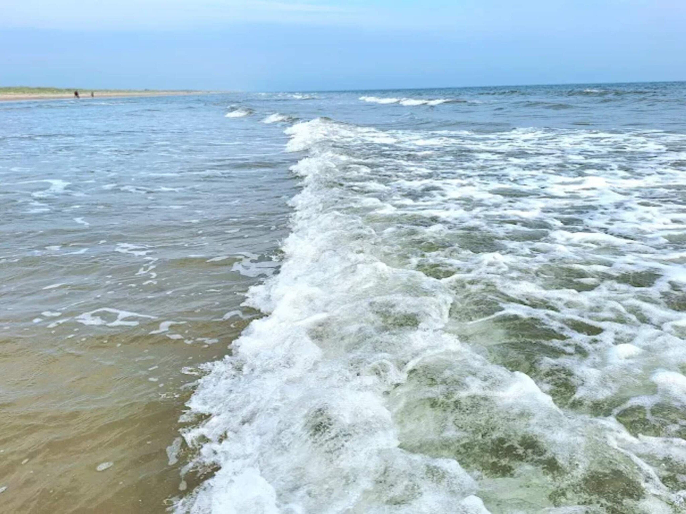 A beach with waves crashing onto the shore.