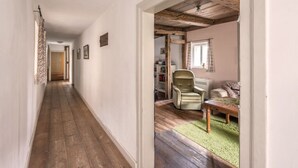 A hallway leading to a room with a wooden ceiling, a radiator, and a green carpet. - Pleasant Apartment in Unsleben (Unsleben)