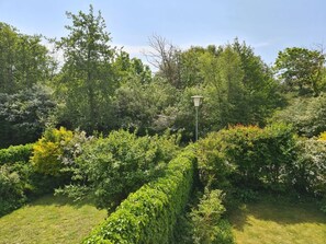 A lush garden with a variety of green shrubs and trees, a neatly trimmed hedge, and a single street lamp. - Borkum Ideal 71 B Comfortable Holiday Residence (Borkum)