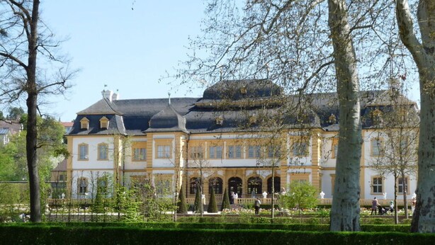 Un grand bâtiment de style classique, doté d’une façade symétrique, de nombreuses fenêtres et d’une entrée centrale flanquée de colonnes.