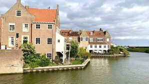 A canal-side building with traditional architecture, a bridge, and a lock system. - Oceanhouse Comfortable Holiday Residence (Wieringerwerf)