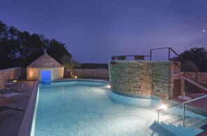 A swimming pool with stone walls and a small building with a blue door. - Arco Comfortable Holiday Residence (Svetvincenat)