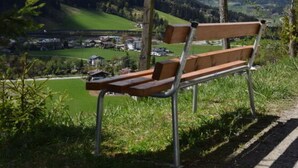 A bench overlooking a valley with mountains in the background. - Apartment Bar Comfortable Holiday Residence (Eben im Pongau)