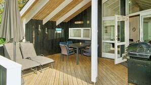 A covered outdoor patio with a table and chairs, a grill, and a covered seating area. - 6 Person Holiday Home in Graested (Graested)