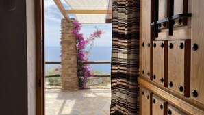 A wooden door with a view of a stone pathway leading to a balcony with a view of the sea. - Villa Near Adra With Sea and Mountain Views (Adra)