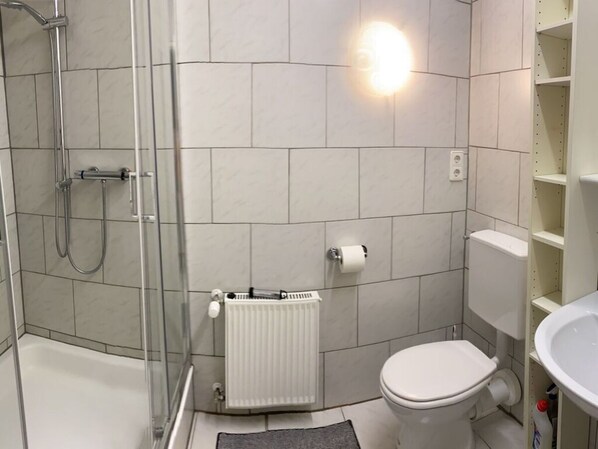 Un baño con ducha, inodoro y lavamanos.