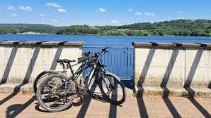 Een betonnen brug met metalen hekwerken en fietsen langs de kant.