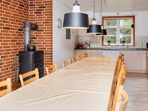 A modern kitchen with a brick wall, a stove, and pendant lights. - 4 Star Holiday Home in Oster Assels (Øster Assels)