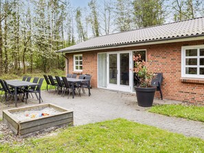 A brick building with a patio, outdoor seating, and a fire pit.