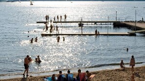A beach with people swimming and walking on the pier. - 4 Star Holiday Home in Vastra Frolunda (Vastra Frolunda)