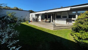 A modern single-story house with a covered patio, a barbecue grill, and a small garden area. - 4 Star Holiday Home in Vastra Frolunda (Vastra Frolunda)