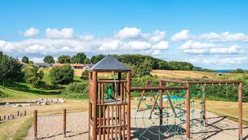 A playground with a climbing structure and a small pavilion.