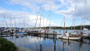 A marina with multiple sailboats docked at wooden piers. - Rose Comfortable Holiday Residence (Kappeln)