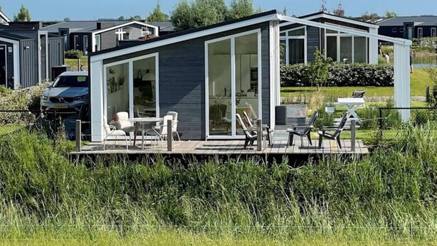 A modern house with a deck, large windows, and a view of the surrounding area. - Dyke-view Stay With Terrace (Wemeldinge)