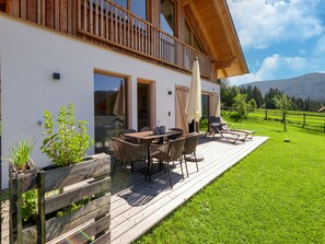 A wooden deck with outdoor furniture, a table, and chairs. - Beautiful Chalet in Wolting With Sauna (Tamsweg)