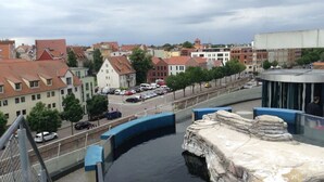 Vista de un canal con un puente de piedra y edificios al fondo.