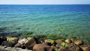 En klar vy över havet med klippor i förgrunden.