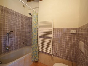 A bathroom with a bathtub, shower, and toilet. - Belvilla by OYO Borgo Sanvico Capanna (Corciano)