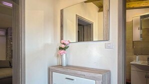 A bathroom with a white cabinet, a mirror, and a vase with pink flowers. - Villa G With Pool in Barban (Barban)