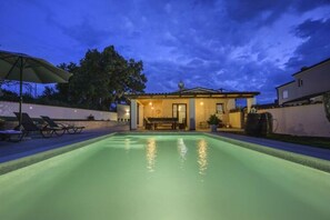 A swimming pool with a patio area, lounge chairs, and a building with a tiled roof. - Villa G With Pool in Barban (Barban)