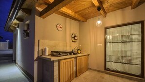 A kitchen with wooden cabinets, a countertop, and a hanging light fixture. - Villa G With Pool in Barban (Barban)