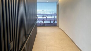 En hall med utsikt över en strand genom ett stort fönster.