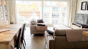 En moderne stue med en sofa, et lille bord og et fjernsyn.