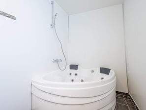 A bathroom with a freestanding bathtub, a showerhead, and a toilet. - 5 Star Holiday Home in Hemmet (Hemmet)