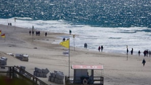 A beach with a lifeguard station, beach chairs, and a flag. - Beach House "blanker Hans" (Sylt)