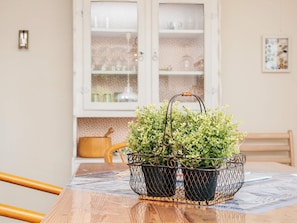 A dining table with a metal plant holder containing green plants. - 5 Person Holiday Home in Skjern (Skjern)