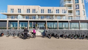 Moderni rakennus, jossa on tasakatto, useita parvekkeita ja suuri lasijulkisivu.