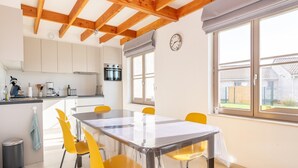 A modern kitchen with white cabinets, a stainless steel oven, and a built-in microwave. - Holiday Home in Koksijde Near Sint-andre Beach (Koksijde)