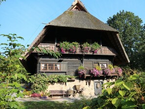 A traditional wooden house with a steeply pitched thatched roof, multiple windows, and flower boxes on the upper floor. - Pleasant Apartment in Zell am Harmersbach (Zell am Harmersbach)