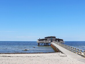 A pier leading to a wooden structure with a flat roof, extending into calm waters. - 4 Star Holiday Home in Bastad (Bastad)