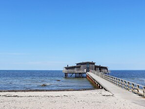 A pier leading to a wooden structure with a flat roof, extending into calm waters. - 4 Star Holiday Home in Bastad (Bastad)