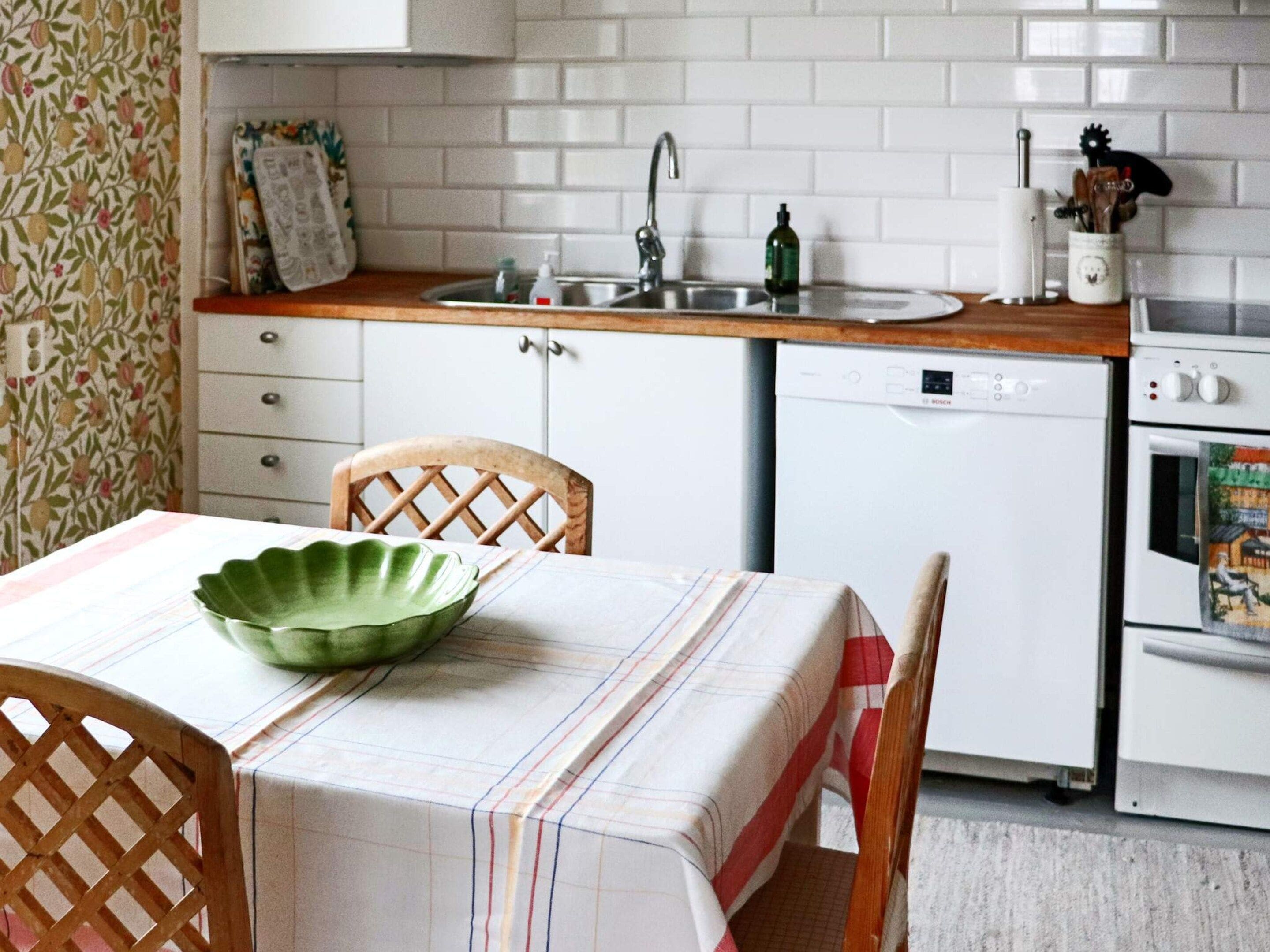 A kitchen with a wooden countertop, a sink, a dishwasher, and a stove.
