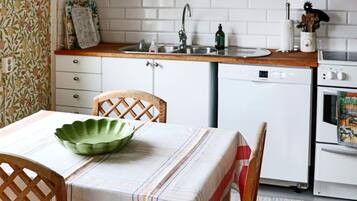 A kitchen with a wooden countertop, a sink, a dishwasher, and a stove.