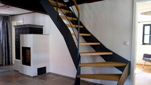 A modern spiral staircase with wooden steps and black metal railings, leading to an upper floor. - Holiday Home Time out in the Monument (Lohr am Main)