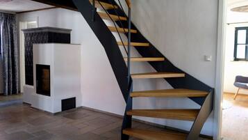 Eine moderne Wendeltreppe mit Holzbodenstufen und schwarzen Metallgeländern, die zu einer oberen Etage führt.