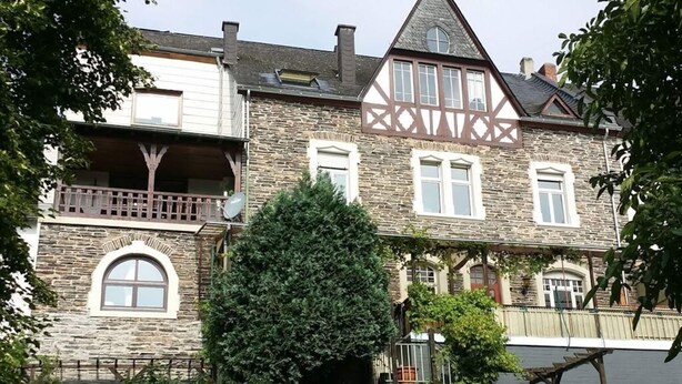 A large, historic stone building with multiple windows, a balcony, and a staircase leading to an upper level. - Vinum Comfortable Holiday Residence (Uerzig)