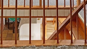 A high-ceilinged room with a wooden staircase, a bathtub, and a green table. - 5 Person Holiday Home in Nexo (Nexø)